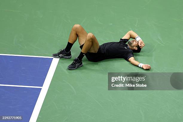 Novak Djokovic of Serbia falls against Mariano Navone of Argentina during their Men's Singles First Round match on Day One of the 2026 US Open at...