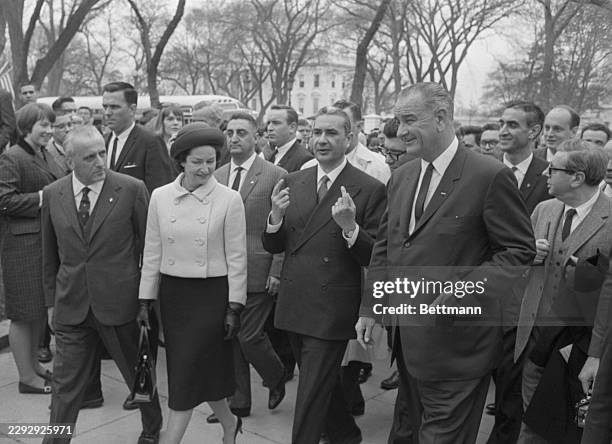President Johnson and Lady Bird escort Italian Prime Minister Aldo Moro from the White House, across Pennsylvania Ave., to the Decatur House where...