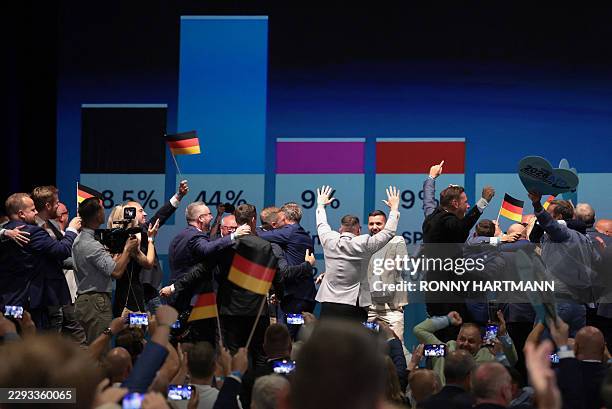 Members and supporters of the far-right Alternative for Germany party react after the first exit poll results were announced on public television at...