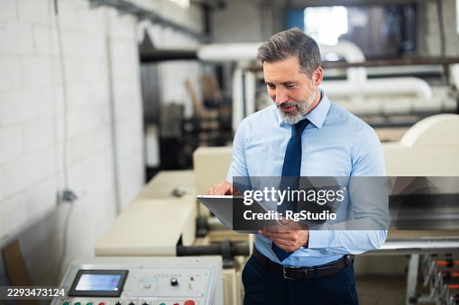 Engineer using digital tablet in factory managing manufacturing Engineer using digital tablet in factory managing manufacturing