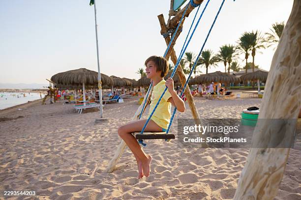 child swinging on beach during summer vacation - swinging stock pictures, royalty-free photos & images
