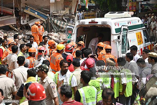 Rescue personnel continue search and rescue operations for the second consecutive day at the site of a five-storey building collapse in Satya...