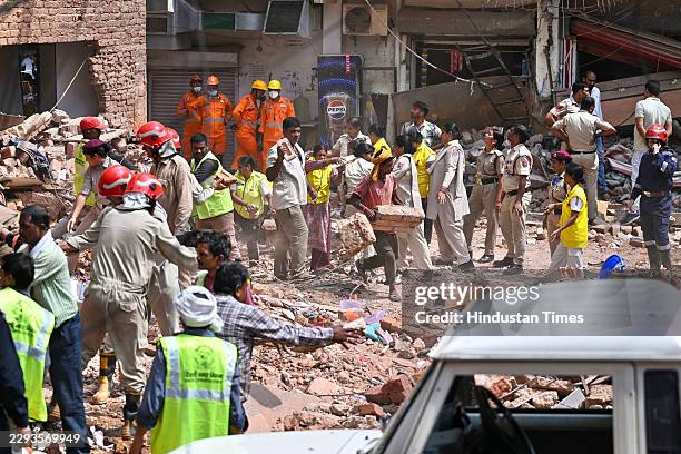 Rescue personnel continue search and rescue operations for the second consecutive day at the site of a five-storey building collapse in Satya...