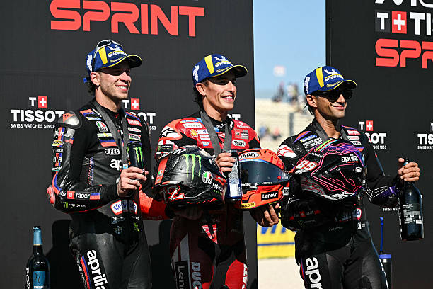 Second place Aprilia Racing's Italian rider Marco Bezzecchi, first place Ducati Lenovo Team's Spanish rider Marc Marquez and third place Aprilia...
