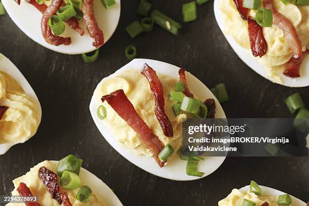 bacon deviled eggs on black background - deviled eggs stock pictures, royalty-free photos & images