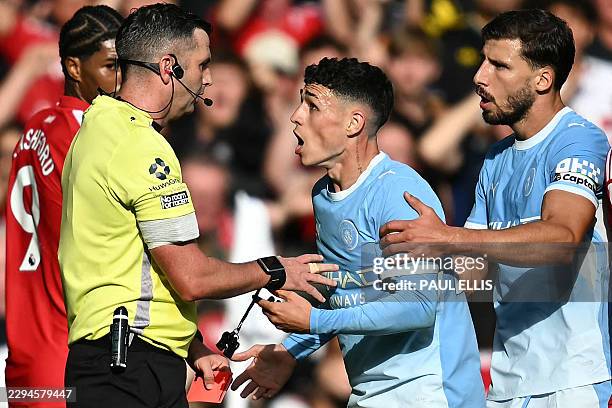 Manchester City's English midfielder Phil Foden reacts to Referee Michael Oliver after being shown a red card during the English Premier League...
