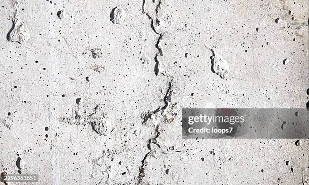 cracked white concrete wall texture with pitted surface - concrete block wall stock illustrations
