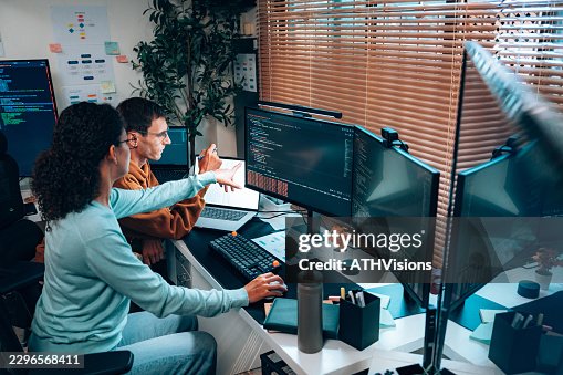 Young Hispanic woman and white male programmers debugging code at workstation Young Hispanic woman and white male programmers debugging code at workstation