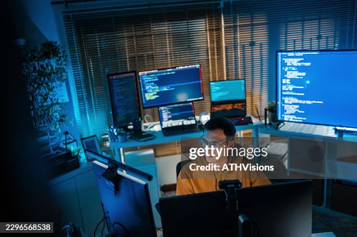 Software Developer Coding at Multi-Monitor Workstation Software Developer Coding at Multi-Monitor Workstation