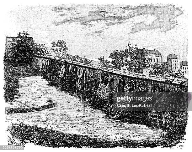 french cemetery wall adorned with circular wreaths and stone structure - funeral flower stock illustrations