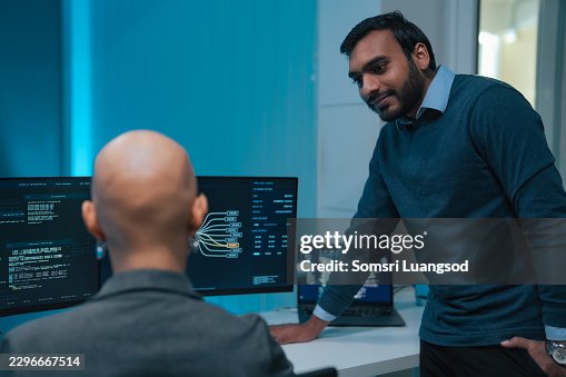 Technology engineer explaining system information to control room operator Technology engineer explaining system information to control room operator