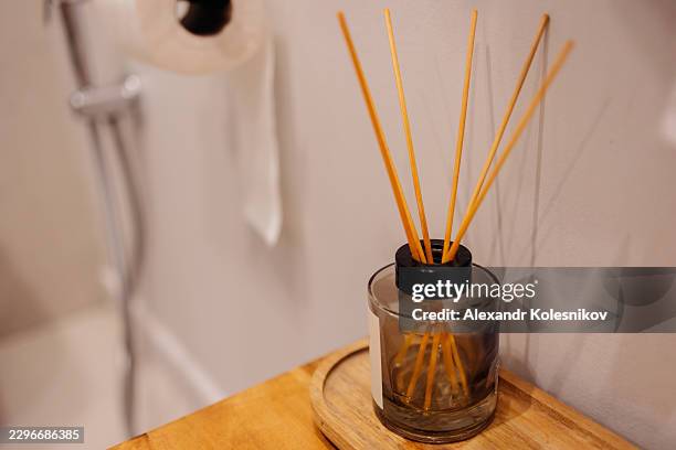 reed diffuser with wooden sticks on a tray adding fragrance to the bathroom space - aromatherapy diffuser stock pictures, royalty-free photos & images