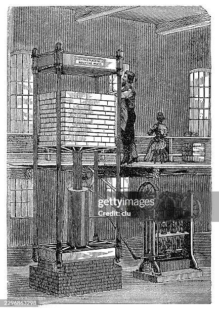 hydraulic press for paper sheets — worker operates a tall hydraulic press in which a large stack of paper sheets is compressed and smoothed between heavy press plates - plates stacking up stock illustrations