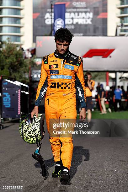 Lando Norris of Great Britain and McLaren looks dejected as he returns to the paddock following his crash at the safety car restart during the F1...