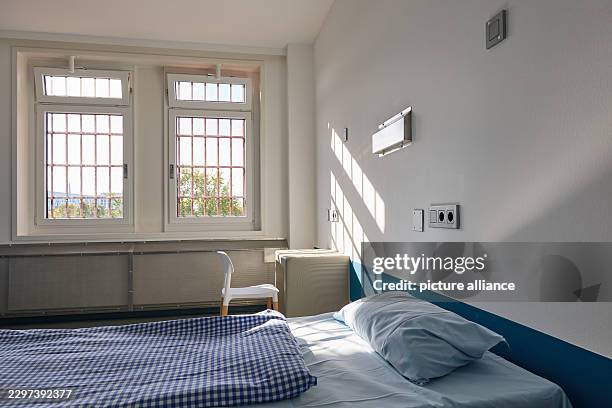 September 2026, Hamburg: Shadows cast by the prison bars fall on a table and a bed in a solitary confinement cell during a press tour marking the...
