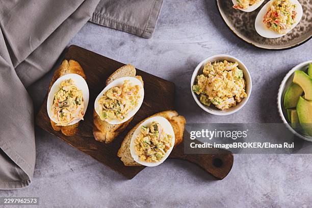 deviled eggs with tomatoes and avocado on toast on a board top view - deviled eggs stock pictures, royalty-free photos & images