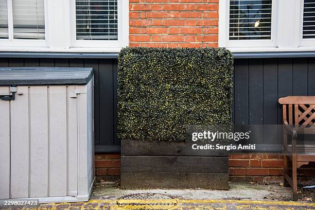 mews frontage with artificial hedge planter and bench - timber window frames stock pictures, royalty-free photos & images