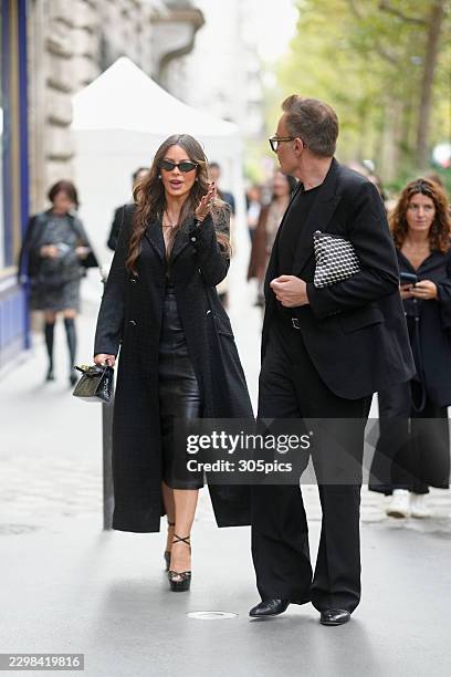 Sofia Vergara is seen wearing black sunglasses, black long coat, black leather midi dress, black ankle-strap platform sandals, while carrying a black...