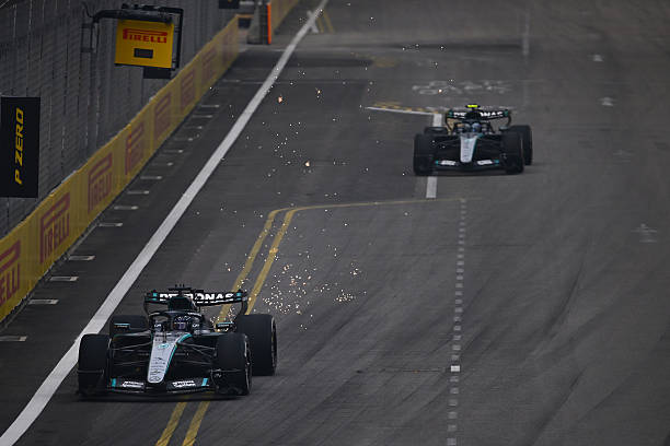 Sparks fly behind George Russell of Great Britain driving the Mercedes AMG Petronas F1 Team W17 as he leads Andrea Kimi Antonelli of Italy driving...