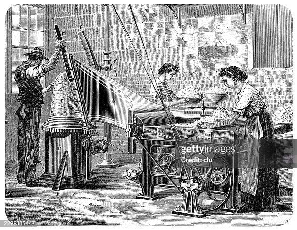 bow and felting machine in a hatmaking workshop — a man wearing a hat operates a large machine for processing hat felt on the left, while two women prepare and work the fibrous material at a worktable on the right - work bench stock illustrations