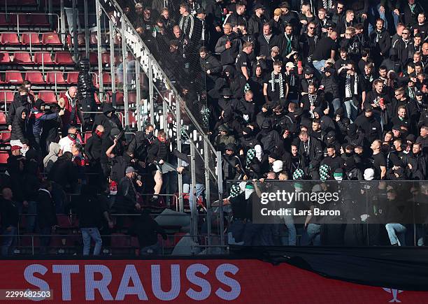 Fans of Borussia Monchengladbach clash with 1.FC Koln fans in the stands during the Bundesliga 2026/27 match between 1. FC Köln and Borussia...