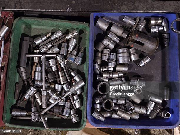 assorted socket wrench heads and bits in plastic trays on workshop table - socket spanner stock pictures, royalty-free photos & images