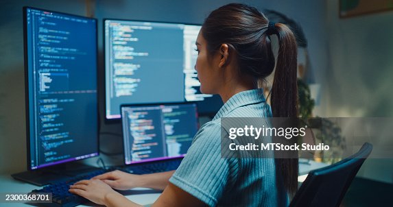 Closeup Gen Z Asian female computer programmer types coding on a computer while working late at night in home office. Software development, digital transformation, artificial intelligence concept. Closeup Gen Z Asian female computer programmer types coding on a computer while working late at night in home office. Software development, digital transformation, artificial intelligence concept.