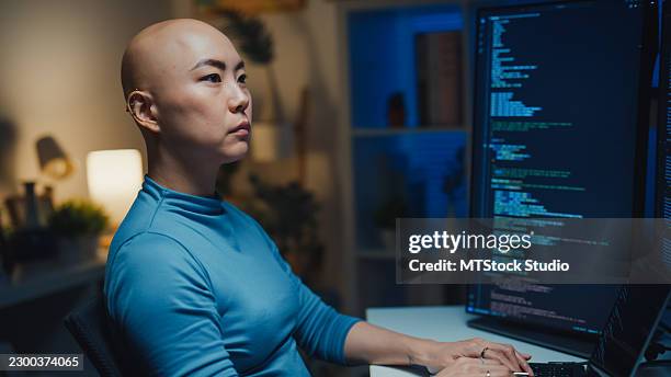 young asian female programmer with cancer patient working late coding on computer in home at night. machine learning, network security, chatbot, software development, artificial intelligence concept. - javascript stock pictures, royalty-free photos & images