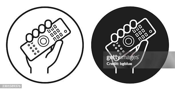 hand holding up remote control. round icon - black and white circle button - holding remote control stock illustrations