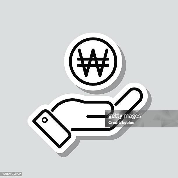 won coin in hand. icon sticker on gray background - treasury stock illustrations