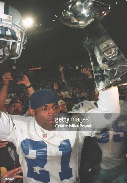 Cornerback Deion Sanders of the Dallas Cowboys holds up the Vince Lombardi Trophy following the Cowboys 27-17 victory over the Pittsburgh Steelers in...