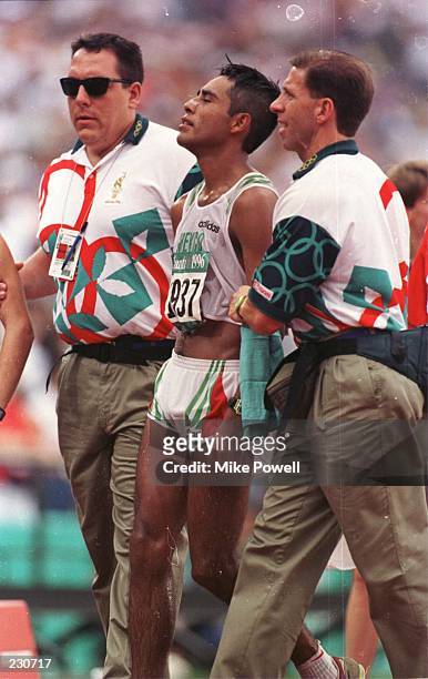 Jefferson Perez of Ecuador is helped by officials after crossing the line to win gold in the mens 20km walk during the 1996 Centennial Games at the...
