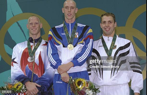 Jeremy Linn of the USA, right, Fred Deburghgraeve of Belgium, center, and Mark Warnecke of Germany on the medal podium for the 100m breastroke at the...