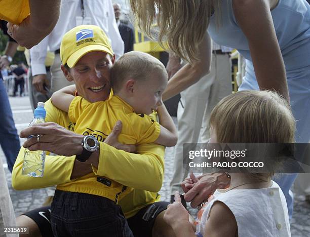 Lance Armstrong gives a hug to his son Luke while his wife Kristin and daughter look on at the end of the 20th and last stage of the 90th Tour de...