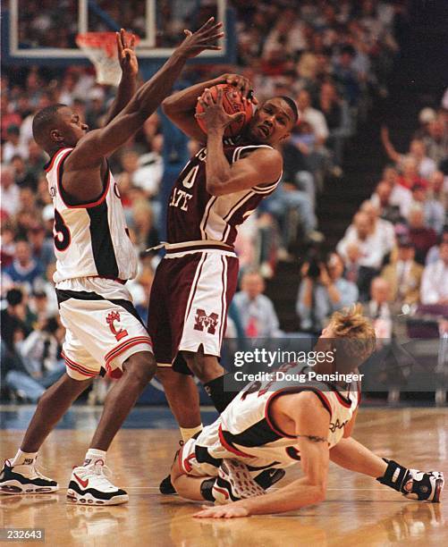 Darnell Burton and Bobby Brannen of Cincinnati play tight defense on Darryl Wilson of Mississippi State in the first half of the NCAA South East...