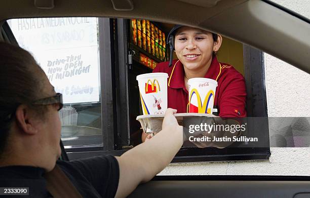 Josephine Hernandez hands a tray of drinks to a drive thru customer at a McDonald's restaurant July 29, 2003 in Redwood City, California. McDonald's...