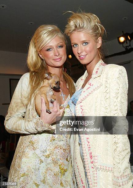 Socialites Nicky Hilton and Paris Hilton holding her pet dog Tinkerbell, attend the Diane von Furstenberg Fall/Winter 2003 Collection fashion show at...