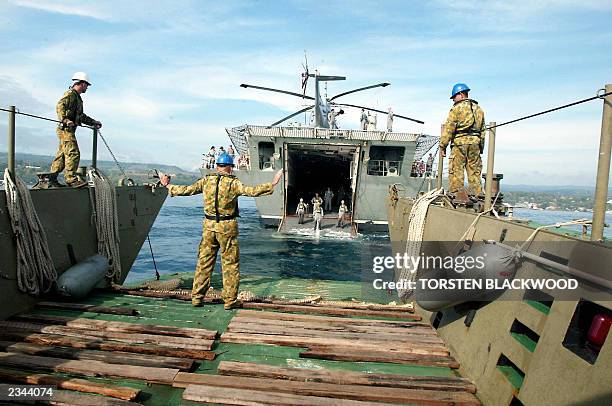 Transport barge approaches the aft door of the HMAS Manoora, which serves as the nerve centre for the Australian-led intervention force, off the...