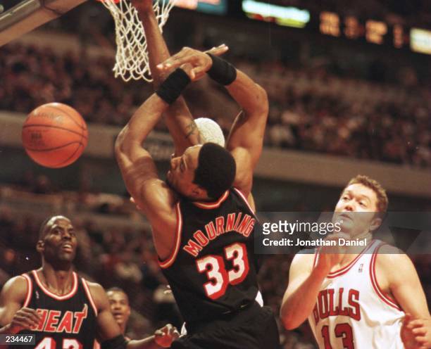 The ball sails out of reach from the grasp of Center Alonzo Mourning, as forward Kevin Willis of the Miami Heat , forward Dennis Rodman , behind...