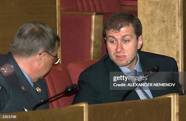 Russian businessman Roman Abramovich talks with a police officer during a Duma session in Moscow 17July 2000. Abramovich purchased 50.09 per cent of...