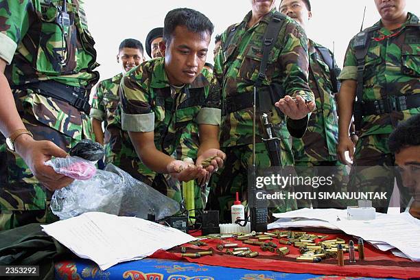 Indonesian soldiers check amunition which they believe belongs to the separatist Free Aceh Movement rebels in Banda Aceh, 31 July 2003. The...