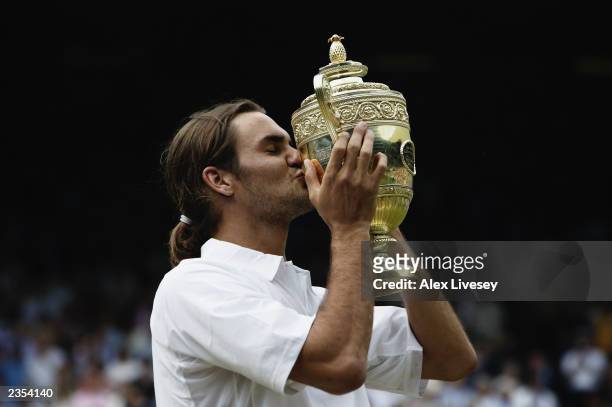 Roger Federer of Switzerland kisses the trophy after his victory over Mark Philippoussis of Australia in the Men's Singles Final during the final day...