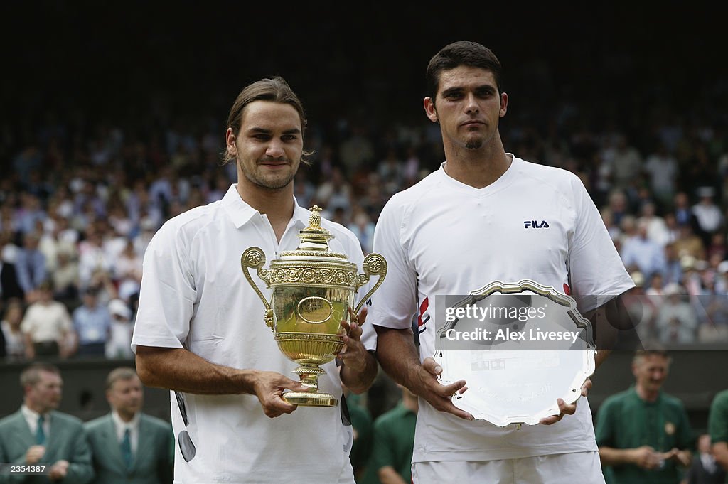 Roger Federer of Switzerland holds the trophy with runner-up Mark Philippoussis of Australia