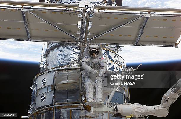 In this image released by the National Aeronautics and Space Administration , astronaut Richard M. Linnehan works to replace the starboard solar...