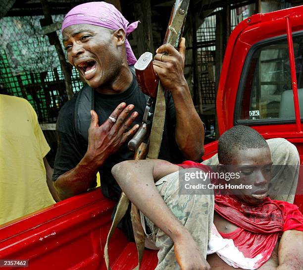 Government loyalist soldier grieves as a comrade dies of wounds suffered during a battle near front line positions August 2, 2003 in Monrovia,...