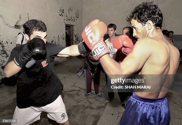 Afghan boxers Abdul Hamid Rahimi , aged 31, and Bashirmal Sultani , aged 19, spar together in Kabul, 28 July 2003, as the two prepare for the...