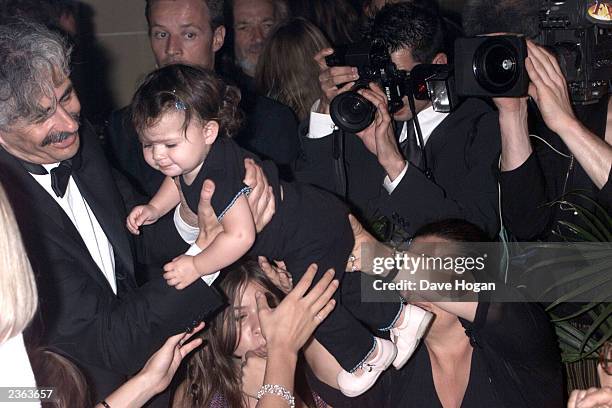 Melanie Blatt's baby, Lilyella Zender, goes to grandad, David Blatt, at the "Honest" party in Cannes.