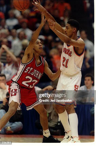 ST. JOHN''S REDMEN GUARD DEREK BROWN TRIES TO BLOCK THE PASS FROM SYRACUSE ORANGEMEN FORWARD LAWRENCE MOTEN DURING A BIG EAST CONFERENCE GAME