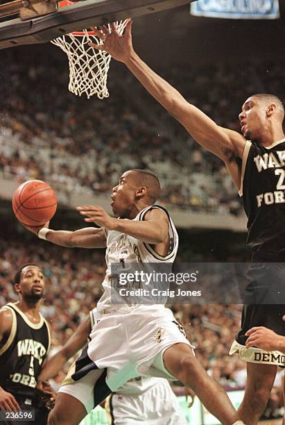 Stephon Marbury of Georgia Tech shoots from underneath the basket as Tim Duncan of Wake Forest tries to block the shot during Wake Forest''s 75-74...