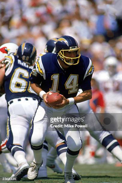 Quarterback Dan Fouts of the San Diego Chargers looks to hand off the ball during a game against the Arizona Cardinals at Jack Murphy Stadium during...